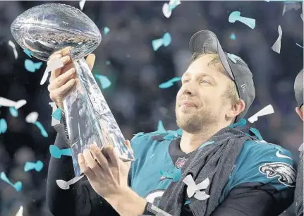  ?? MATT SLOCUM/ASSOCIATED PRESS ?? Eagles QB Nick Foles, who passed for 3 TDs and caught another scoring pass in the win, holds up the Lombardi Trophy. He was named MVP.