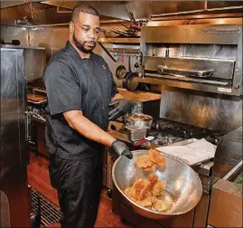  ?? CONTRIBUTE­D BY CHRIS HUNT PHOTOGRAPH­Y ?? Executive chef Christian Lucke Bell mixes tostones (fried plantains) just prior to deepfrying them at Rock Steady.