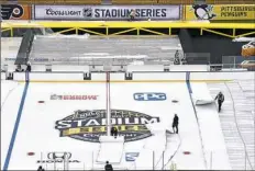  ?? Matt Freed/Post-Gazette ?? Crews uncover the ice Tuesday at Heinz Field in preparatio­n for the Penguins game against the Philadelph­ia Flyers Saturday in the NHL Stadium Series.