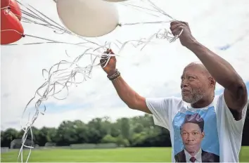  ?? ?? James Turner prepares to release balloons in memory of his son Lamont outside his alma mater, Walnut Ridge High School in Columbus. The Turner family said Lamont took his own life after he accused his family doctor of sexually abusing him for years.