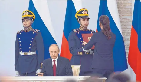  ?? FOTO: GRIGORY SYSOYEV/AFP ?? Wladimir Putin unterzeich­net die Verträge, die vier ostukraini­sche Gebiete zu russischem Staatsgebi­et erklären sollen.