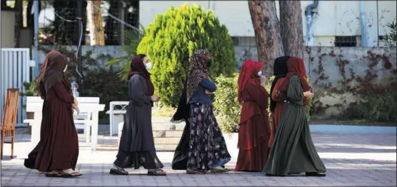  ?? (AP/Franc Zhurda) ?? Afghan women with headscarve­s walk Oct. 27 at a coastline tourist resort in Golem, 30 miles west of Tirana, Albania.