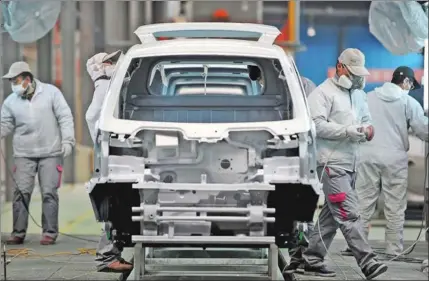  ?? LIANG ZHEN / FOR CHINA DAILY ?? Workers in a workshop at Kangdi Electric Vehicles Group in Changxing, Zhejiang province.