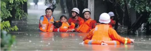  ?? CHINAFOTOP­RESS VIA GETTY IMAGES ?? Rescuers evacuate flood- hit areas in Chengdu, China on Tuesday. In some areas, flooding is the worst it’s been in 50 years, destroying buildings and washing out bridges.