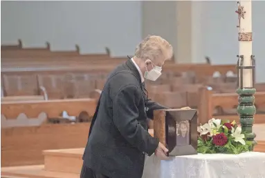  ?? PHOTOS BY NICK OZA/THE REPUBLIC ?? Dino Cervigni brings the cremains of his wife, Marilyn Elizabeth Cervigni, to St. Thomas Aquinas Catholic Church for a funeral service attended by a limited number of family and friends. She died of COVID-19.