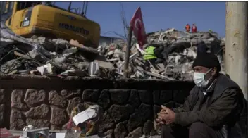  ?? KHALIL HAMRA — THE ASSOCIATED PRESS ?? A man sits next to the rubble of destroyed buildings in Adiyaman, southern Turkey, Sunday.