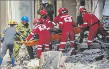  ?? RAMON ESPINOSA/AP ?? Rescuers recover a body at the site of Friday’s deadly explosion that destroyed the five-star Hotel Saratoga, in Havana, Cuba on Saturday.