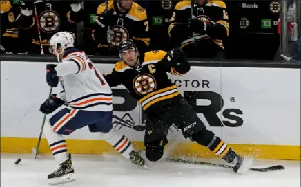  ?? STUART CAHILL / BOSTON HERALD ?? bruins center Patrice bergeron slips on his stick as Edmonton’s Evan bouchard eludes him on Thursday night at the Garden.