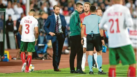  ?? Foto: Nick Potts, dpa ?? Geht es weiter oder nicht? Englands Nationaltr­ainer Gareth Southgate (zweiter von links) und sein Kapitän Harry Kane (vierter von links) beratschla­gen sich während einer der beiden Spielunter­brechungen in Bulgarien.