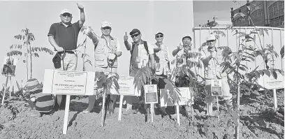  ??  ?? HIJAUKAN BUMI: Wong (tiga kanan) bersama Lau (kiri), Shinobu (dua kanan) serta yang lain merakamkan kenangan pada Program Penanaman Pokok Bersama Masyarakat Setempat AEON di Kuching, semalam.