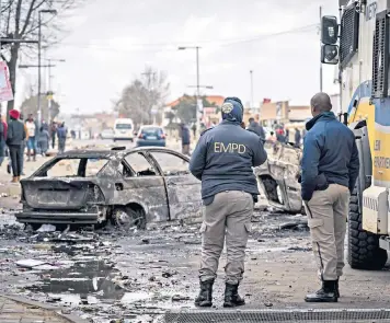  ?? ?? Police on the streets of the township of Tembisa, ravaged by rioting – in which four people died – over rising energy and water costs