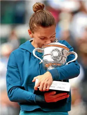  ?? GETTY IMAGES ?? Simona Halep cradles and kisses the French Open trophy, after winning her first grand slam title with victory over Sloane Stephens in Paris.