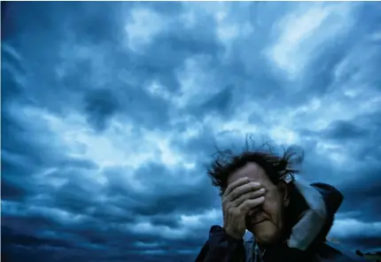  ?? Associated Press ?? ■ Russ Lewis covers his eyes from a gust of wind and a blast of sand Friday as Hurricane Florence approaches Myrtle Beach, S.C.