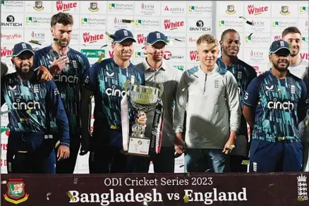  ?? ?? England’s captain Jos Buttler (center), and teammates pose with the winners trophy after the third one day internatio­nal cricket match between Bangladesh and England in Chattogram, Bangladesh. England won the series 2-1. (AP)