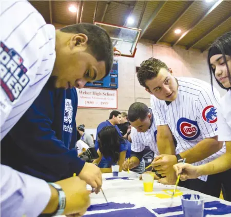  ??  ?? Anthony Rizzo paints with eighth- grader Aubrey Cervantes at Northwest Middle School on Thursday. | JAMES FOSTER/ FOR THE SUN- TIMES