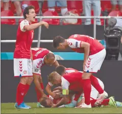  ?? Photo: Nampa/AFP ?? On the mend… Denmark players helping teammate midfielder Christian Eriksen after he collapsed during their UEFA EURO 2020 match against Finland at the Parken Stadium in Copenhagen on Saturday.