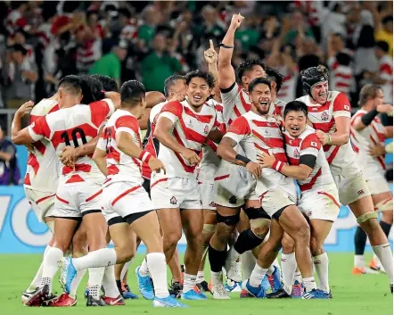  ?? AP ?? Japan celebrate their upset win over Ireland last night.