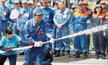  ??  ?? Ready, steady, aim!: Abe participat­ing in a disaster drill in Odawara. — AFP