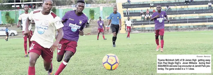  ?? KAVARLY ARNOLD ?? Tiyame McIntosh (left) of St James High getting away from Paul Bogle High’s Jevan Williams during their ISSA/WATA daCosta Cup encounter at Jarrett Park yesterday. The game ended in a 1-1 draw.