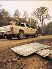  ??  ?? MARK PETERSON, one of hundreds who lost homes in the Carr fire, rescues his goats with the help of a friend. More than 1,500 structures have burned.