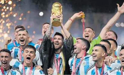  ?? AFP ?? Para la eternidad. Messi levanta la Copa del Mundo en Qatar, rodeado por sus compañeros.