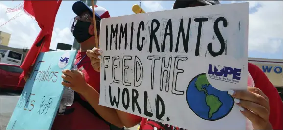  ?? JOEL MARTINEZ/THE MONITOR VIA AP ?? Members of La Union del Pueblo Entero and others hold signs near the McAllen bus station in support of immigrants entering the United States in McAllen, Texas.