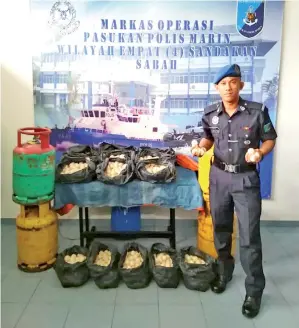  ??  ?? ANGGOTA polis marin menunjukka­n telur penyu yang dirampas bersama empat tong gas kosong.