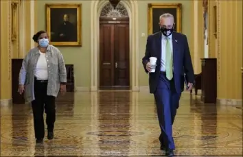  ?? Joshua Roberts/Getty Images ?? Senate Majority Leader Chuck Schumer, D-N.Y., arrives at his office before opening the Senate for debate on a $1 trillion infrastruc­ture bill Saturday in Washington. The closely divided Senate will continue debate on the bill that will greatly expand spending on roads, bridges and mass transit if passed.