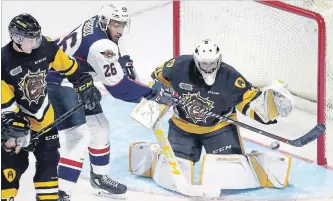  ?? NICK BRANCACCIO THE WINDSOR STAR ?? Spitfires’ Cole Purboo reaches to tip the puck against Hamilton Bulldogs rookie goaltender Zachary Roy and Michael Renwick on Sunday in Windsor.