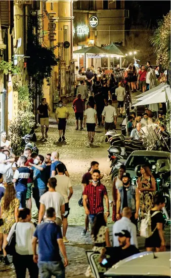  ?? (Ansa) ?? A Roma
La vita notturna romana lo scorso sabato tra via Benedetta e piazza Trilussa, a Trastevere: persone con e senza mascherina. Dopo i recenti focolai, in Italia c’è un allarme che riguarda il rispetto del distanziam­ento sociale nei posti affollati, non solo nelle località di vacanza