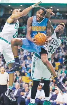  ??  ?? The Nuggets’Will Barton drives past Celtics guards Avery Bradley, left, and Marcus Smart. Charles Krupa, The Associated Press