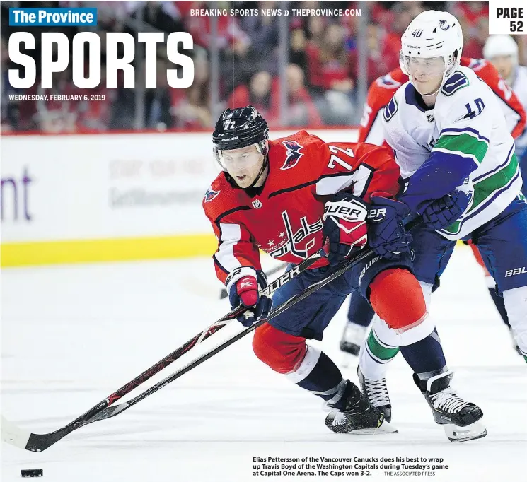  ?? — THE ASSOCIATED PRESS ?? Elias Pettersson of the Vancouver Canucks does his best to wrap up Travis Boyd of the Washington Capitals during Tuesday’s game at Capital One Arena. The Caps won 3-2.