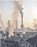  ?? KEVIN FRAYER/GETTY IMAGES ?? Smoke billows from a large steel plant as a laborer works at an unauthoriz­ed steel factory in Inner Mongolia, China. A new report points to China as the source of rising emissions.