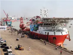  ??  ?? CHITTAGONG: Workers look on as Malaysian ship Nautical Aliya, with relief aid for Rohingya Muslims, is unloaded as she sits moored at the port of Chittagong. —AFP