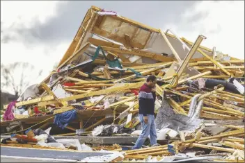  ?? CHRIS MACHIAN/AP ?? GOPALA PENMETSA walks past his house after it was leveled by a tornado near Omaha, Neb., on Friday.