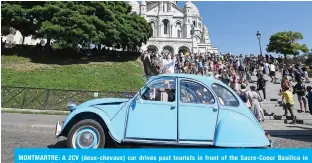  ?? —AFP ?? MONTMARTRE: A 2CV (deux-chevaux) car drives past tourists in front of the Sacre-Coeur Basilica in Montmartre Paris’ district.
