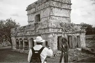  ?? Emilio Espejel / Associated Press ?? A tourist poses for a photo during a visit to the Mayan ruins of Tulum in Mexico’s Quintana Roo state. More U.S. tourists came here during this pandemic-stricken holiday season than last year.