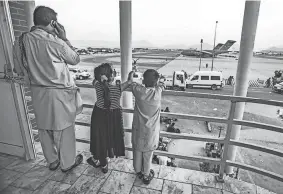 ?? 1ST LT. MARK ANDRIES/U.S. MARINE CORPS VIA GETTY IMAGES ?? Two children point at an aircraft at Hamid Karzai Internatio­nal Airport in Kabul, Afghanista­n, on Aug. 21. Afghans trying to reach the Kabul airport face a dangerous trip.