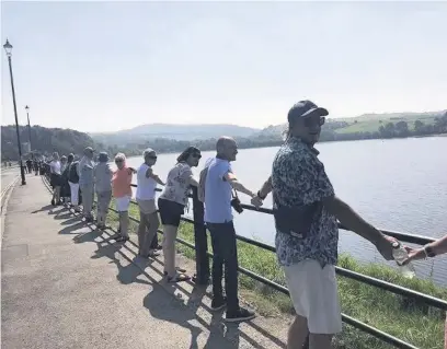  ??  ?? ●●The second Hands around Hollingwor­th Lake protest against plans to build on green belt land