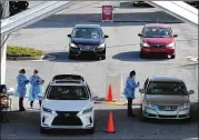  ??  ?? Motorists line up at the Doraville drive- through site. The Centers for Disease Control and Prevention recommends that people get tested ahead of the holidays, though the agency warned it “does not eliminate all risk.”