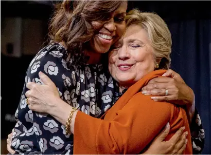  ?? AP ?? US first lady Michelle Obama and Democratic presidenti­al candidate Hillary Clinton hug after speaking at a campaign rally at Wake Forest University in Winston-Salem on Thursday. —