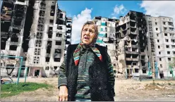  ?? REUTERS ?? A woman reacts as she stands in front of a building, destroyed by the shelling, amid the Russian invasion of Ukraine, in Borodianka, Kyiv region, on Monday.