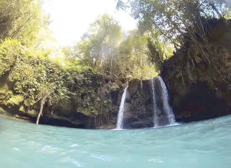  ?? Photos by Alexis Casas ?? Waiting game: After jumping the terrifying 40-foot drop into the Kawasan river, the group watched their guide show them just exactly how it’s done.