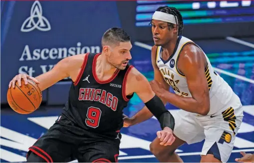  ?? MICHAEL CONROY/AP ?? Bulls center Nikola Vucevic, driving on Pacers center Myles Turner, scored 32 points on 14 of 29 shooting. He added 17 rebounds.
