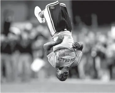  ?? Associated Press ?? n Ozell Williams performs a somersault as part of pregame ceremonies Oct. 15, 2016, before Colorado hosts Arizona State in Boulder, Colo. Williams, a coach who was shown on video pushing cheerleade­rs down in splits, was fired from another Colorado high...