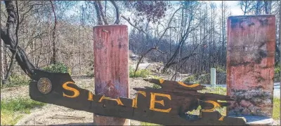  ??  ?? A sign marking the state park is damaged from the 2020 CZU Lightning Complex Fire.