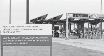  ?? Billy Calzada / Staff photograph­er ?? A sign announces to drivers entering the U.S. from Mexico that a biometric test is underway. Drivers can opt out of the test by choosing a lane without a camera.