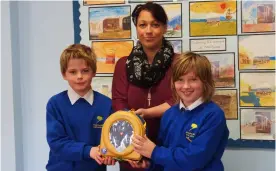  ?? Picture: Gemma Davidson ?? Chair of the school council Harry Floyd and Year 5 council representa­tive Eddie Dixon-Ainscough receive the defibrilla­tor from Claire Page.