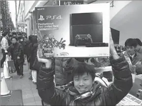  ??  ?? A man holds a PS 4 that he has just bought. (Photo: yahoonews)