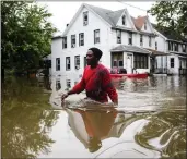  ?? MATT ROURKE — THE ASSOCIATED PRESS ?? Chris Smith makes his way through floodwater­s Thursday to a Baptist church in Westville, N.J.